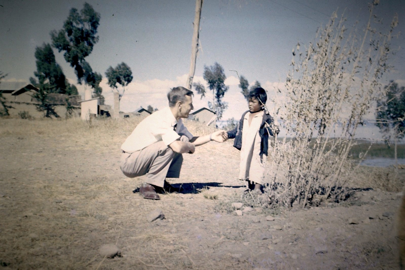 RAF pilot Ronald Walker crouching to greet a local Egyptian child during his service posting in the early 1950s